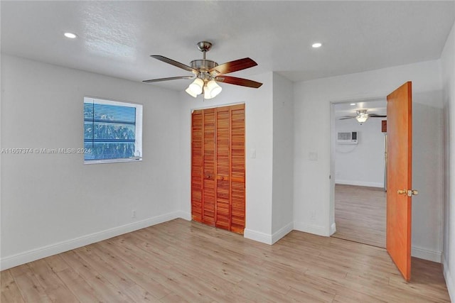 spare room with light wood finished floors, a ceiling fan, and baseboards