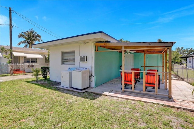 rear view of house featuring separate washer and dryer, a lawn, and a patio area