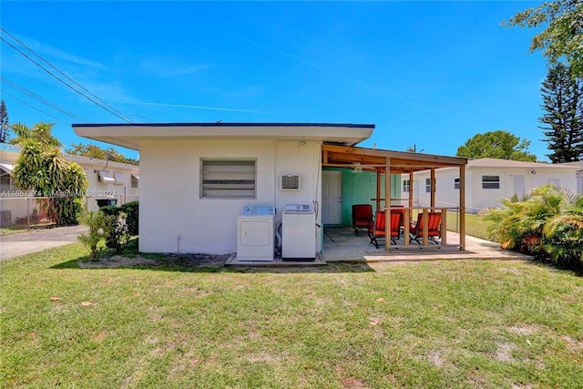 rear view of property featuring washer and dryer, a lawn, and a patio