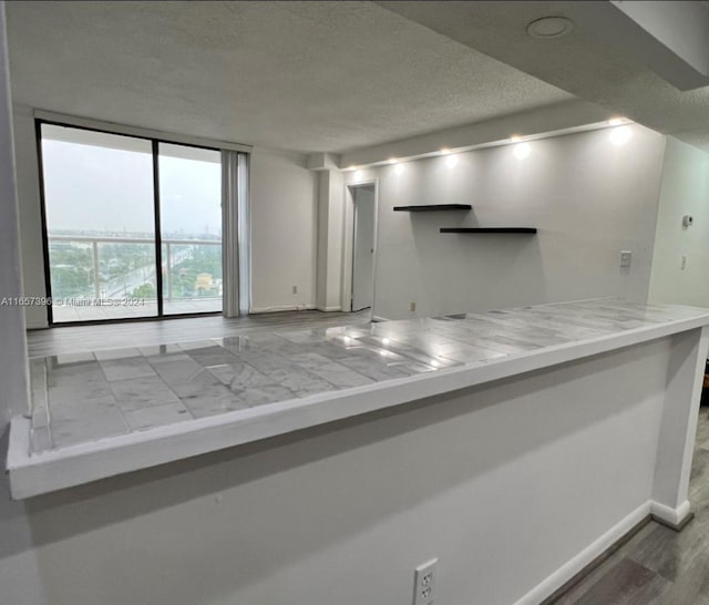 kitchen featuring hardwood / wood-style floors and a textured ceiling