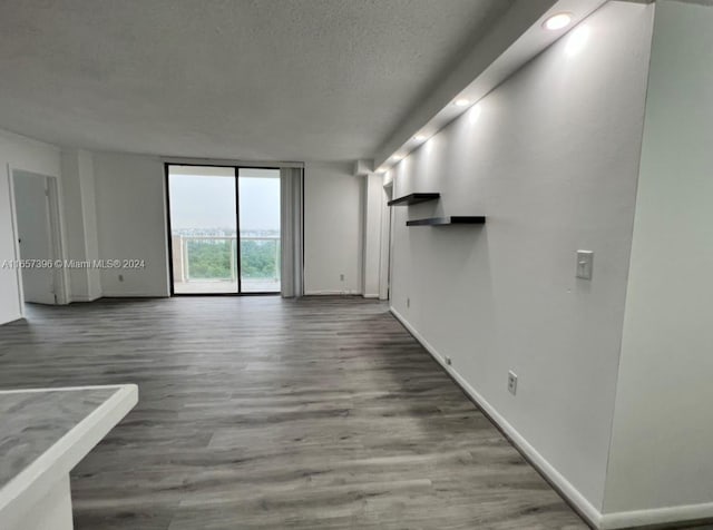 unfurnished living room featuring hardwood / wood-style flooring and a textured ceiling