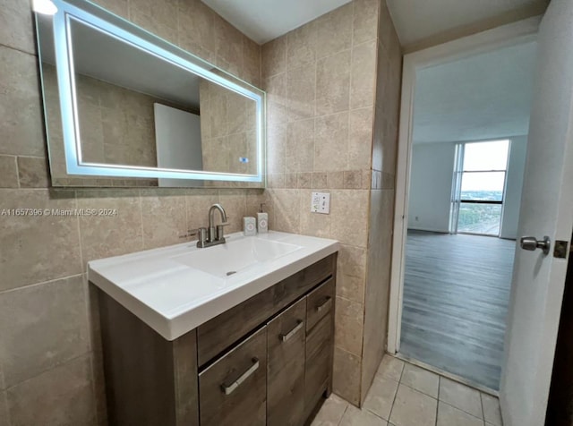 bathroom with vanity, hardwood / wood-style floors, and tile walls