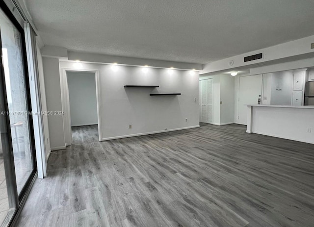 unfurnished living room featuring a textured ceiling and hardwood / wood-style flooring