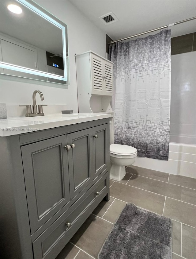 full bathroom with tile patterned flooring, toilet, shower / tub combo, and vanity