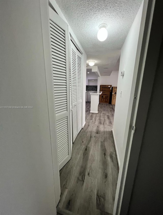 13499 Biscayne Blvd Unit 1205, North Miami, FL 33181 - corridor with wood finished floors, a textured ceiling, and baseboards