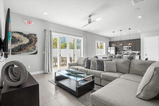 tiled living room with a textured ceiling and ceiling fan