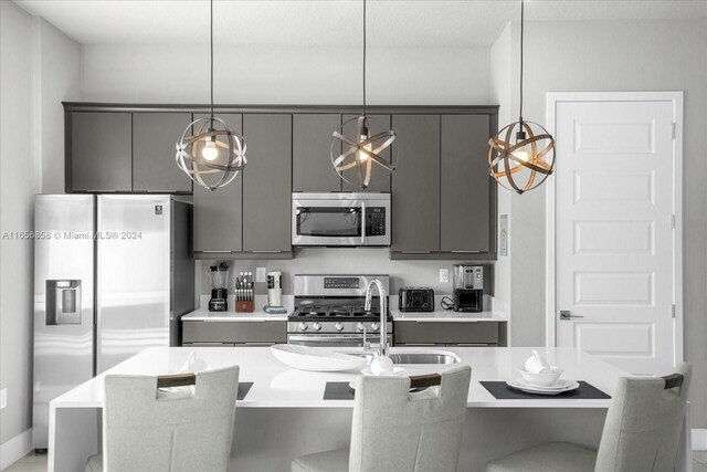7740 Sandy Ridge Dr Unit 112, Kissimmee, FL 34747 - kitchen with appliances with stainless steel finishes, gray cabinetry, and a kitchen breakfast bar