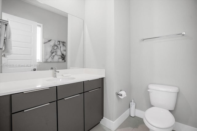 bathroom with tile patterned flooring, vanity, and toilet