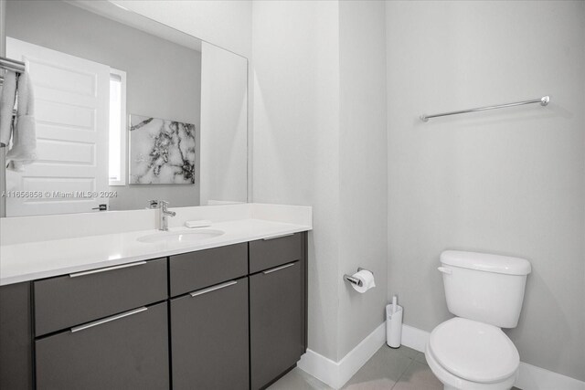 7740 Sandy Ridge Dr Unit 112, Kissimmee, FL 34747 - bathroom with baseboards, toilet, vanity, and tile patterned floors