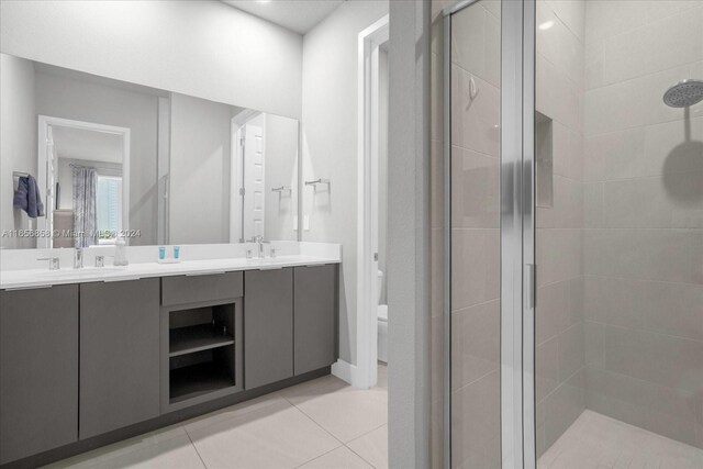 7740 Sandy Ridge Dr Unit 112, Kissimmee, FL 34747 - full bathroom featuring a stall shower, double vanity, toilet, and tile patterned flooring