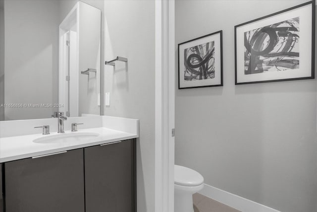 bathroom featuring tile patterned flooring, vanity, and toilet