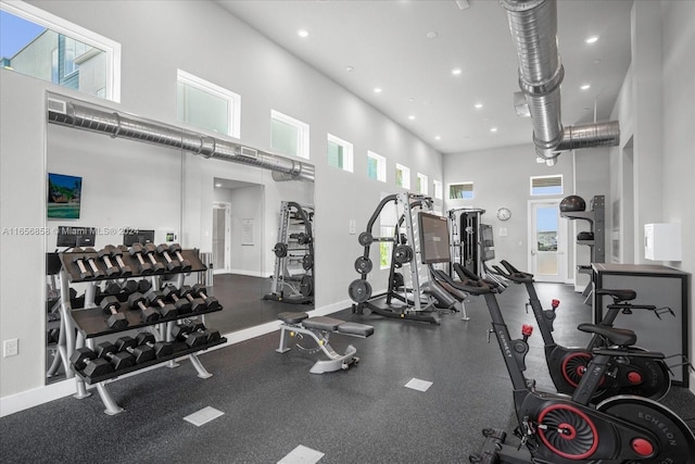 workout area featuring a towering ceiling