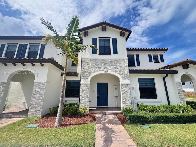 mediterranean / spanish-style house with a front yard