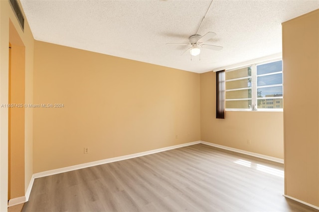 unfurnished room featuring ceiling fan, a textured ceiling, and wood-type flooring