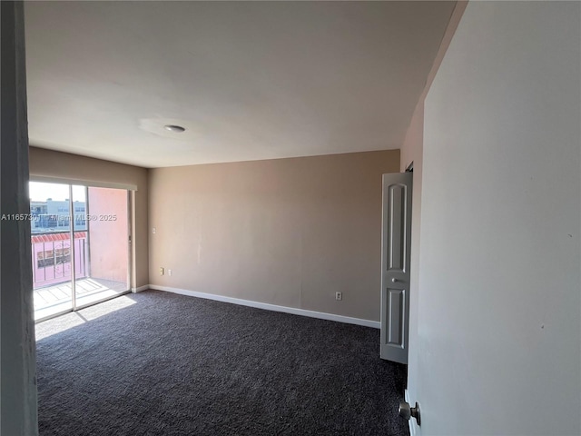 spare room featuring dark colored carpet