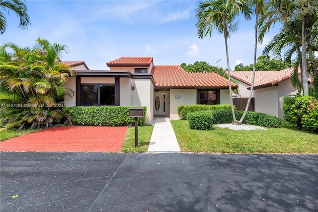 mediterranean / spanish-style house with a front lawn