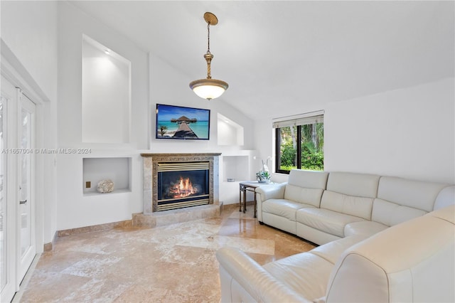 living room featuring a tile fireplace and vaulted ceiling