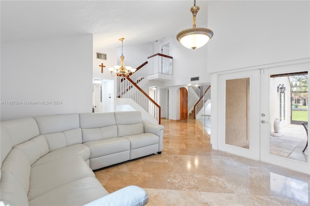 living room featuring a towering ceiling and a chandelier