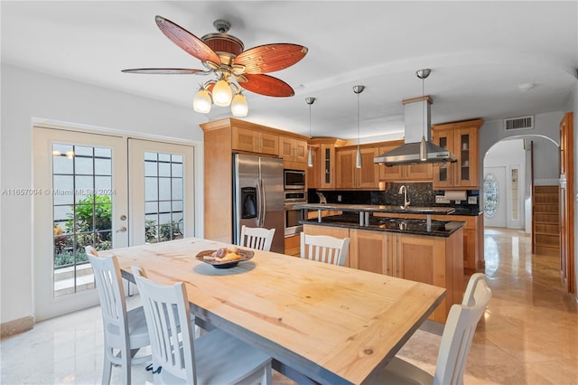 tiled dining room featuring ceiling fan, sink, and french doors