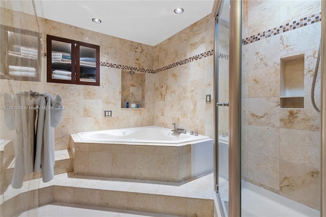 bathroom featuring plus walk in shower and tile walls