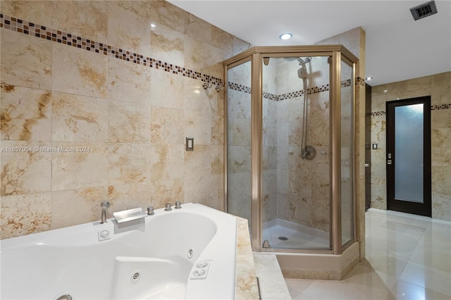 bathroom featuring plus walk in shower, tile walls, and tile patterned flooring