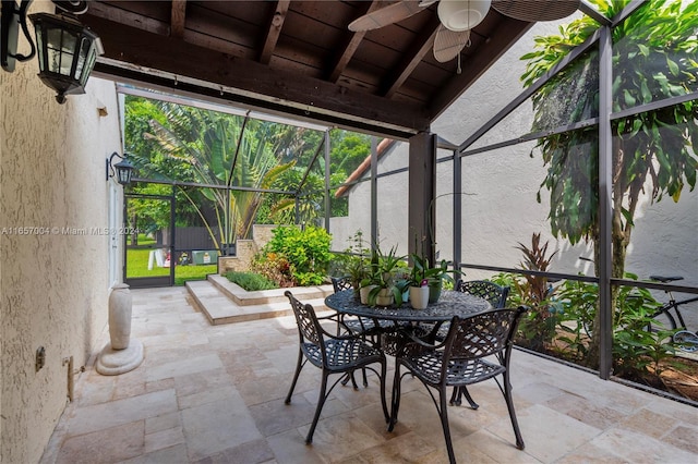 unfurnished sunroom featuring ceiling fan and a wealth of natural light