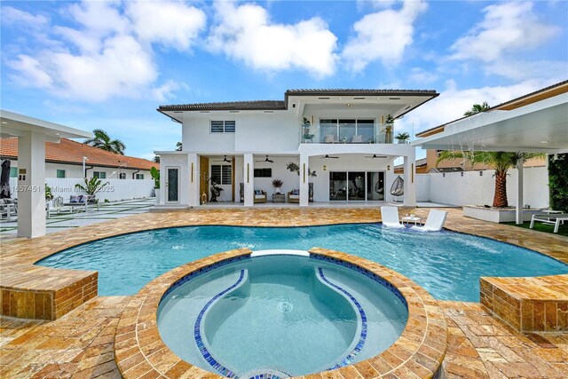 view of pool with an in ground hot tub, pool water feature, ceiling fan, and a patio