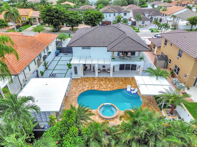 exterior space with ceiling fan, exterior kitchen, an outdoor wet bar, pool water feature, and a swimming pool with hot tub