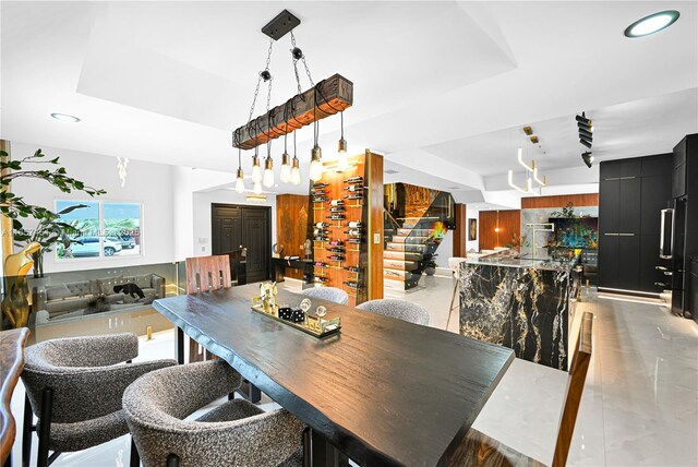 kitchen featuring decorative backsplash, stainless steel dishwasher, dark stone counters, sink, and pendant lighting