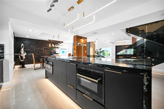 kitchen featuring high end refrigerator, backsplash, and dark stone countertops