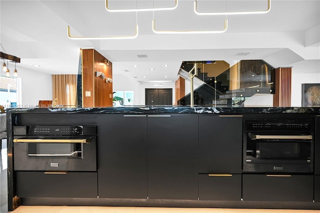 kitchen featuring dark stone countertops and oven