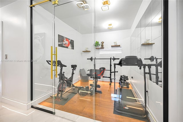 exercise room with light wood-type flooring