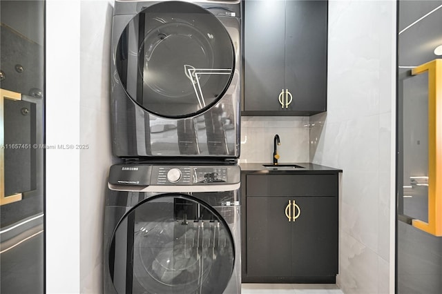 washroom with cabinets, stacked washing maching and dryer, sink, and tile walls