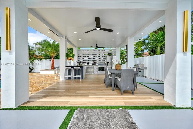 view of patio / terrace featuring ceiling fan, a grill, and exterior bar