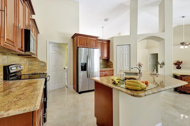 kitchen featuring high vaulted ceiling, range with electric stovetop, backsplash, and stainless steel refrigerator with ice dispenser