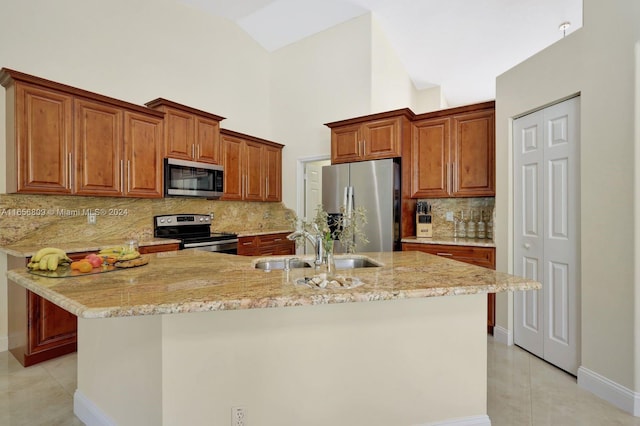 kitchen with light tile patterned floors, light stone countertops, stainless steel appliances, sink, and decorative backsplash