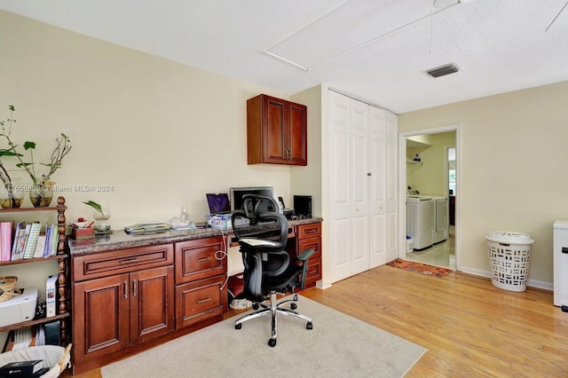 office area featuring a textured ceiling, light hardwood / wood-style flooring, and washer and clothes dryer