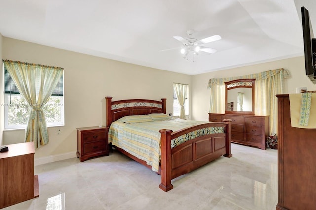 bedroom with ceiling fan and a tray ceiling