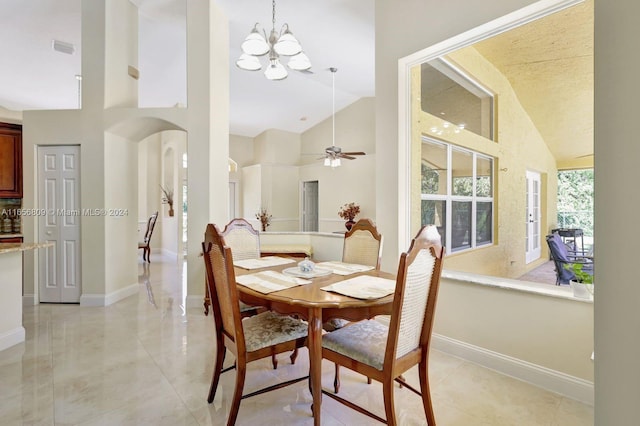 tiled dining room with ceiling fan with notable chandelier and high vaulted ceiling