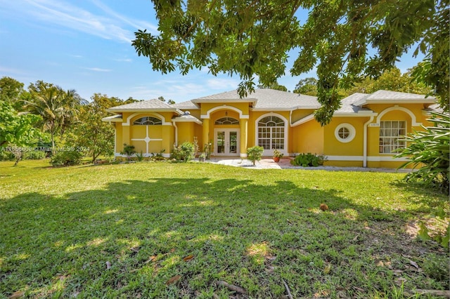 rear view of property featuring a lawn and french doors