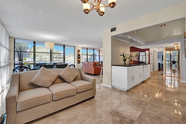 living room featuring a wall of windows, a chandelier, and a textured ceiling