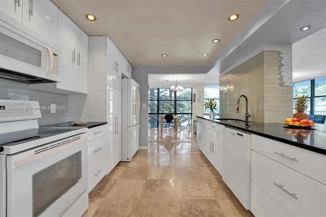 kitchen featuring a notable chandelier, white cabinetry, white appliances, sink, and decorative backsplash