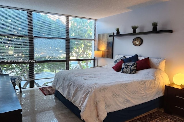 bedroom with a textured ceiling and floor to ceiling windows