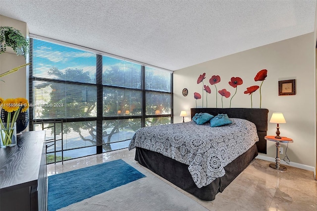 bedroom with a textured ceiling and a wall of windows