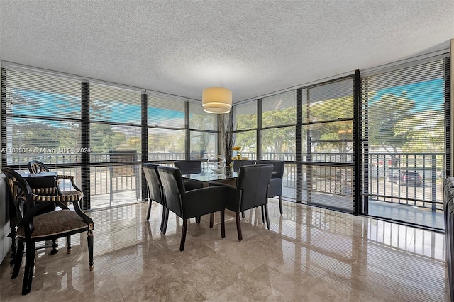 dining area featuring a textured ceiling and a wall of windows