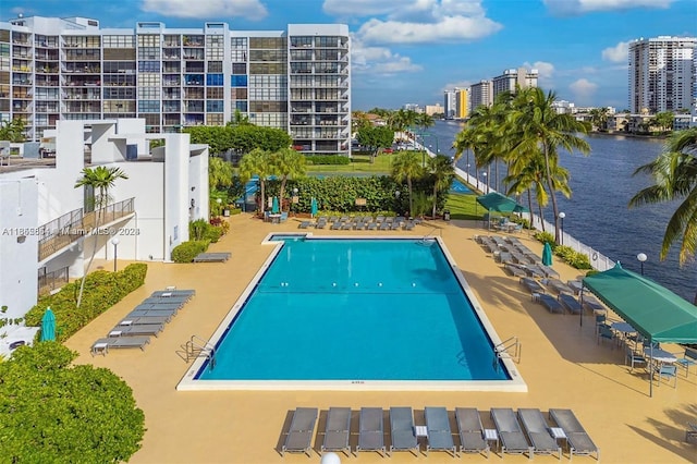 view of pool with a patio area and a water view