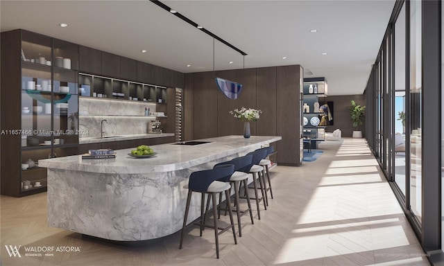 bar with light parquet floors, pendant lighting, sink, and dark brown cabinetry