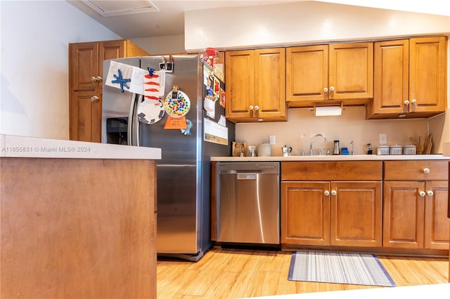 kitchen featuring light wood-type flooring, appliances with stainless steel finishes, and sink