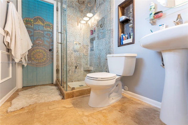 bathroom featuring toilet and a shower with door