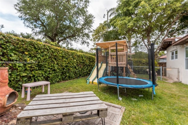 view of yard with a trampoline and a playground